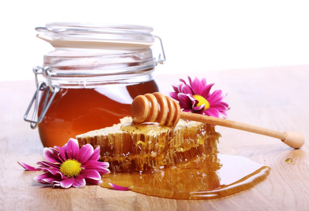 Healing powers of pure honey – natural remedy for wounds, cough, and skin health – honeycomb and jar of golden honey with dipper