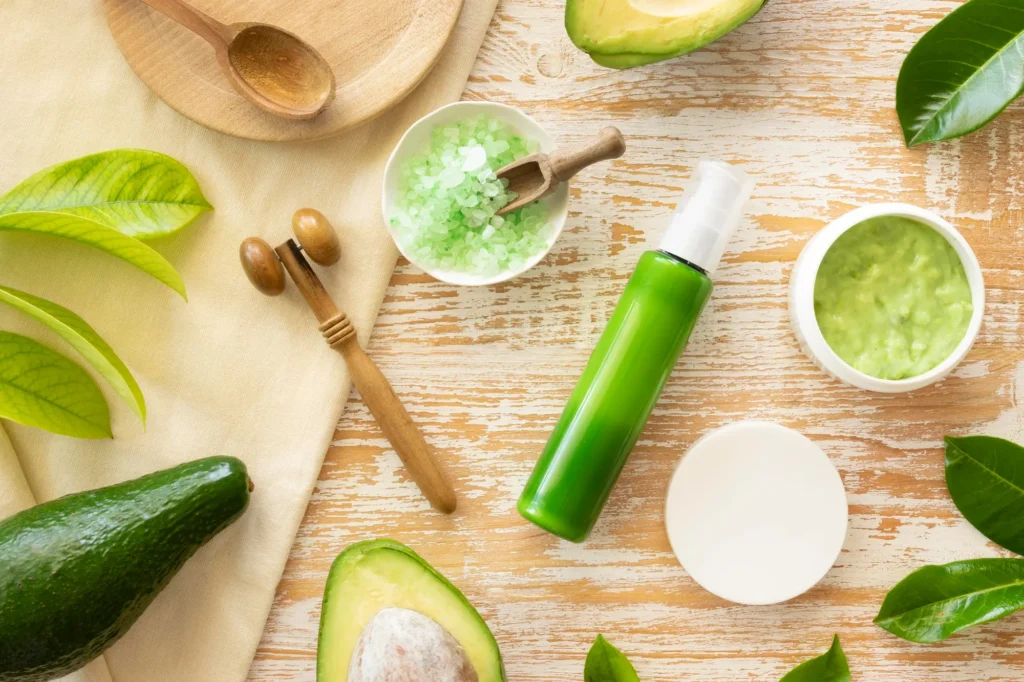 Top organic foods for glowing skin including fresh avocados, vibrant berries, leafy greens, and sweet potatoes displayed on a rustic wooden table, symbolizing nutrient-rich skincare and wellness.
