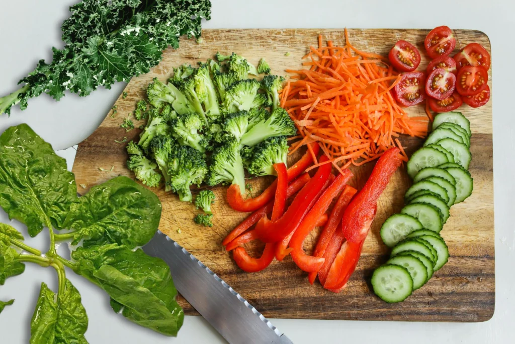 Fresh organic vegetables arranged on a rustic wooden table, including vibrant leafy greens, tomatoes, carrots, and broccoli, promoting a chemical-free, nutrient-rich diet.