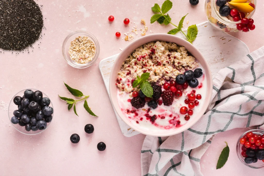 A nutrient-rich anti-inflammatory breakfast bowl featuring creamy oatmeal topped with fresh blueberries, blackberries, red currants, and chia seeds. A glass of mixed berries and oats sits nearby, highlighting a fiber-packed, gut-friendly meal perfect for a 30-day anti-inflammatory diet plan.