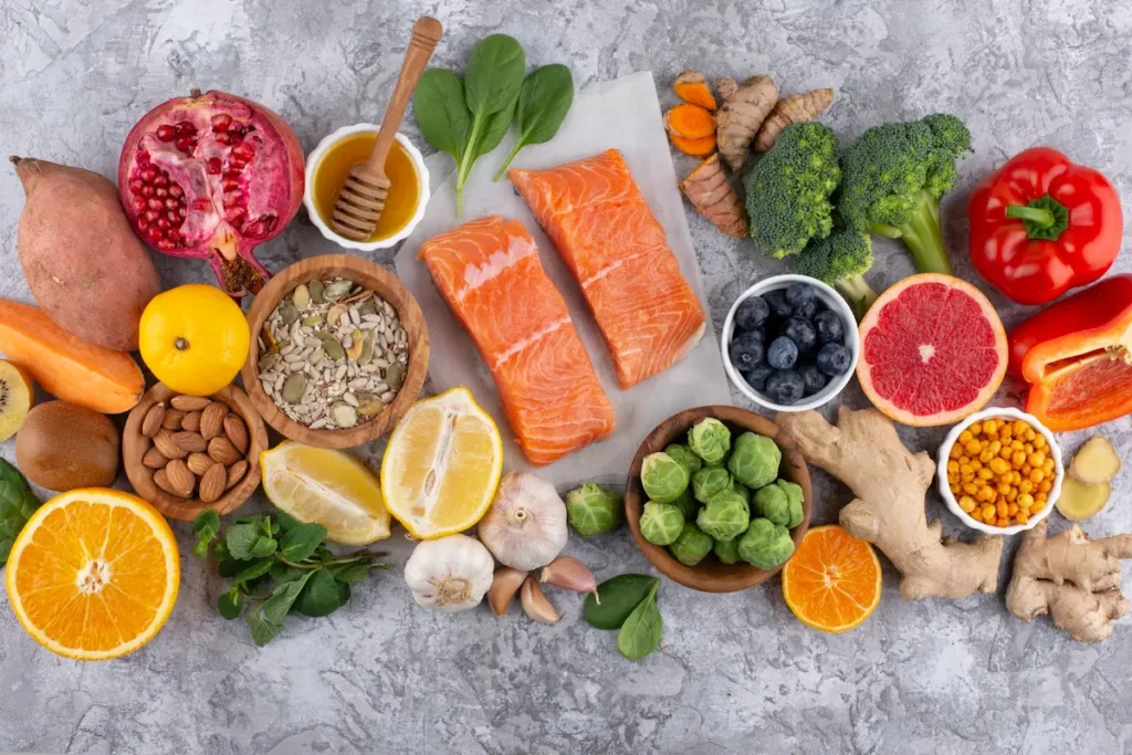 Fresh anti-inflammatory diet foods arranged on a counter, featuring wild-caught salmon, raw turmeric, blueberries, and leafy greens.