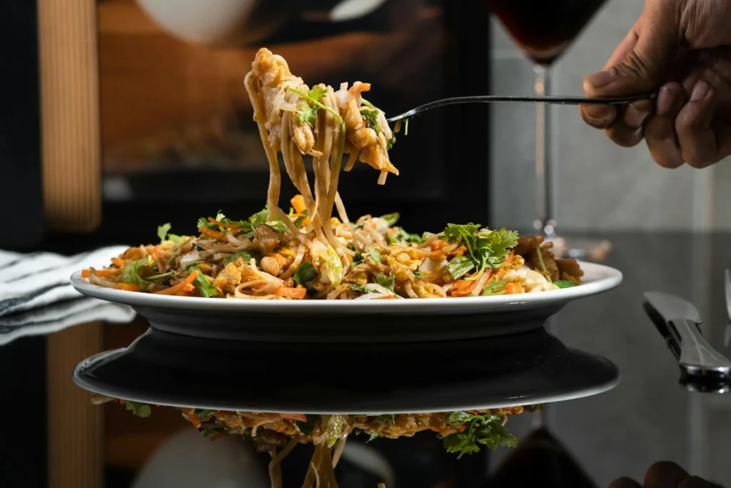 High protein pasta dish with vegetables being lifted by a fork
