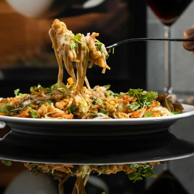 High protein pasta dish with vegetables being lifted by a fork