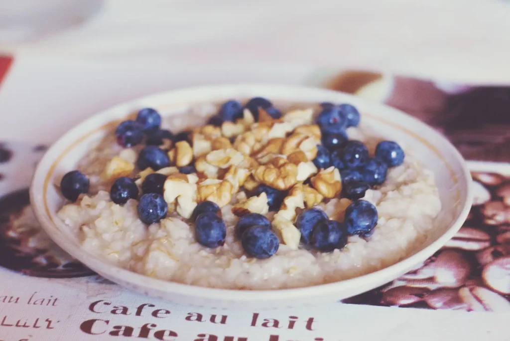 A warm bowl of rolled oats topped with chopped walnuts and fresh blueberries for a heart-healthy Mediterranean breakfast.
